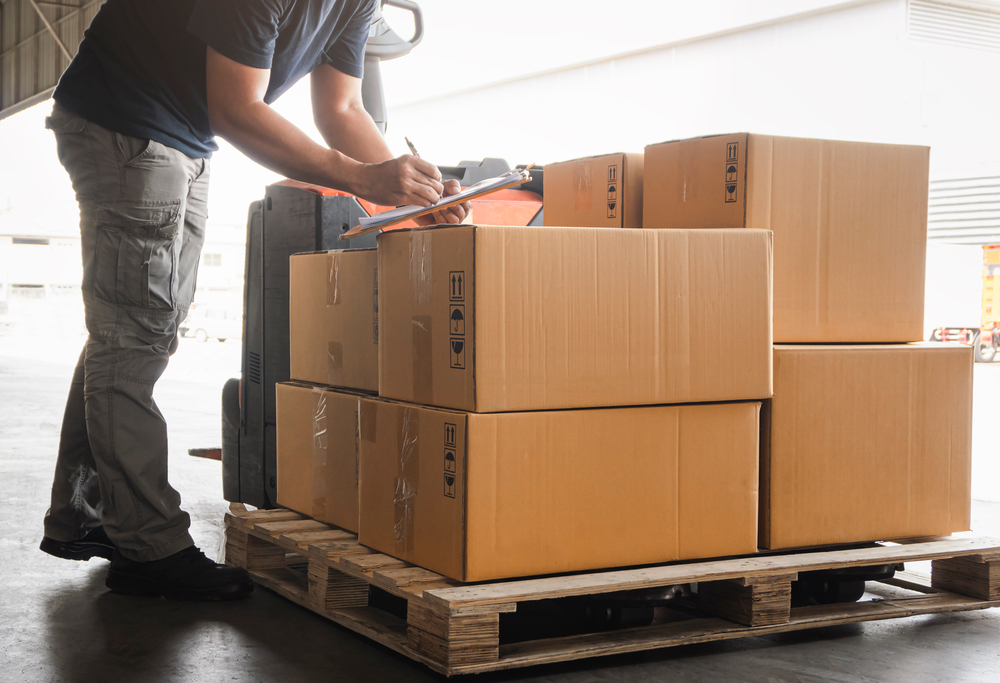 Warehouse,Worker,Holding,Clipboard,His,Doing,Inventory,Management,Cargo,Boxes.